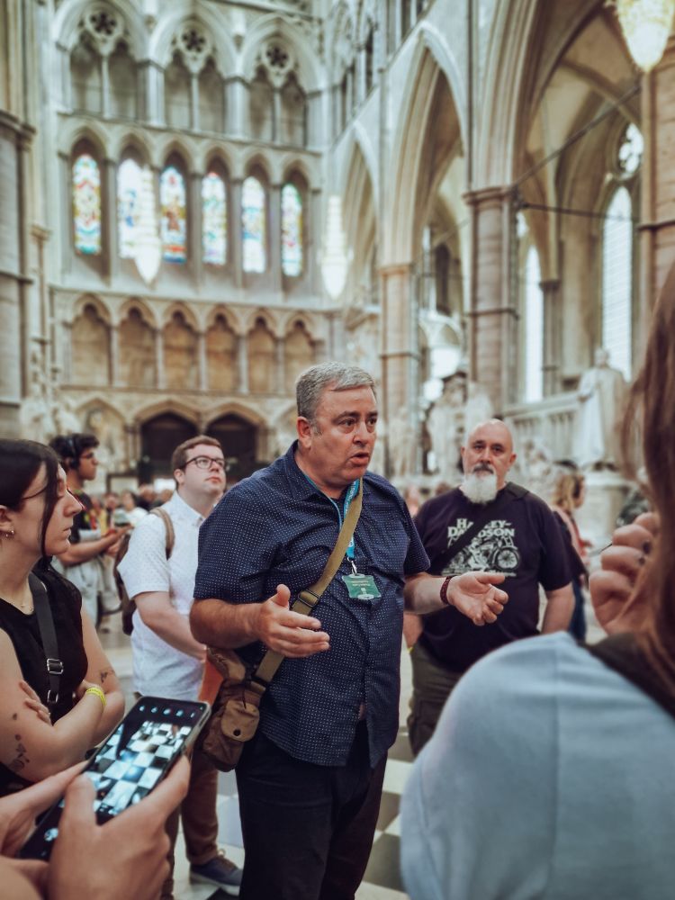 tour group listening to guide inside westminster abbey in london
