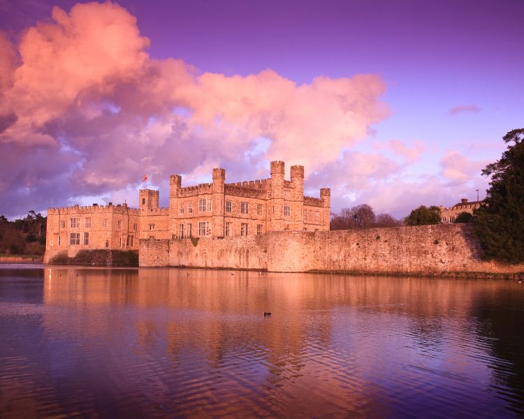 leeds castle seen across the river under a pink sky
