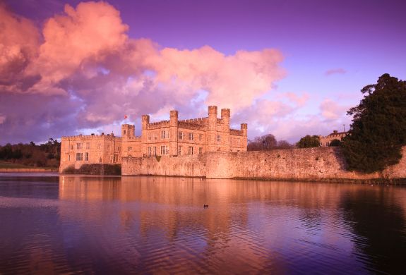 leeds castle seen across the river under a pink sky