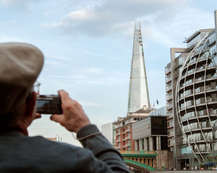man taking a photo of the top of the shard on a tour of london