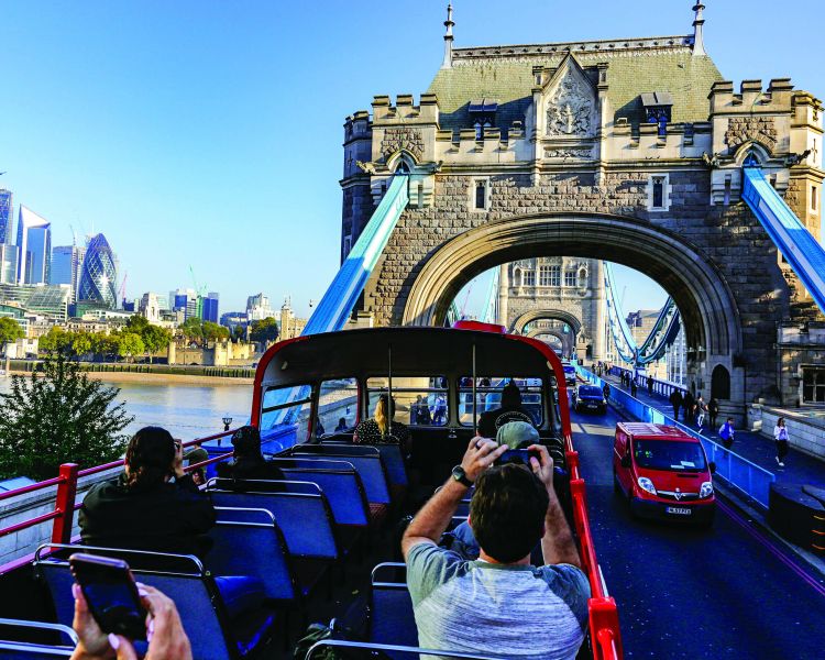 sightseeing tour bus going over tower bridge in london