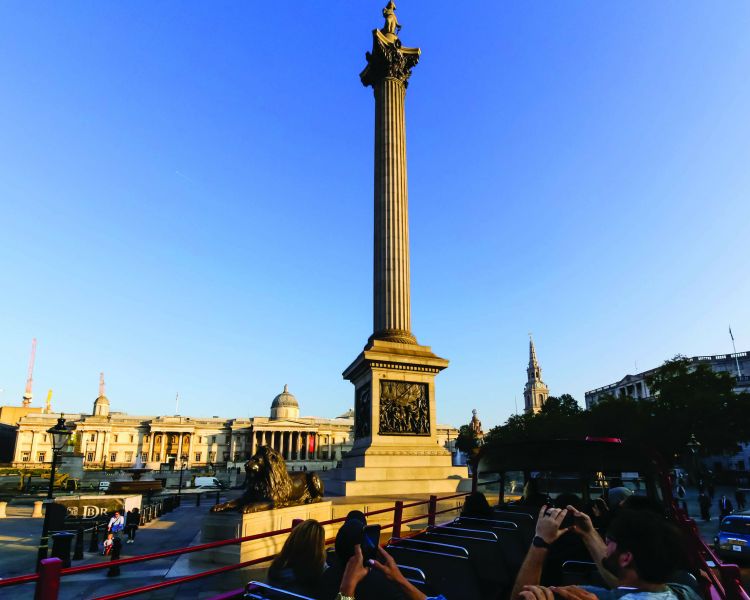 london sightseeing tour bus going past trafalgar square