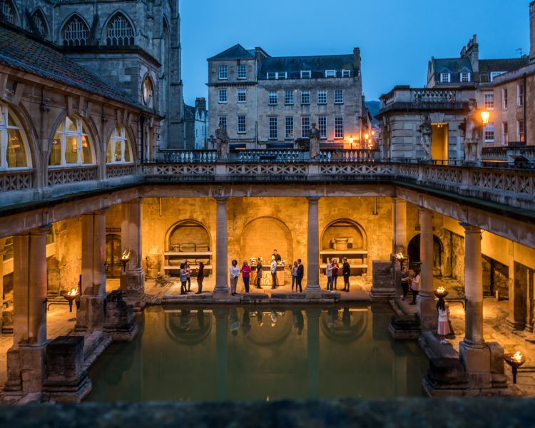 the roman baths in bath lit up at dusk