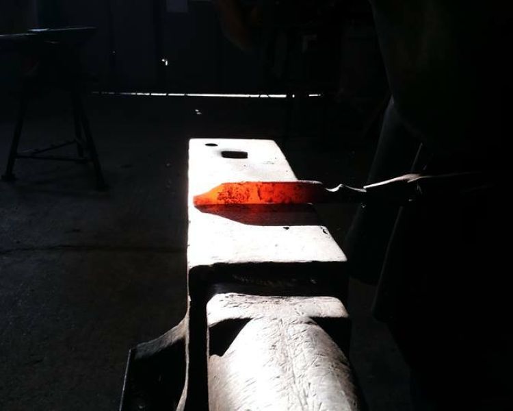 piece of hot metal being hit into shape on a forge a knife experience