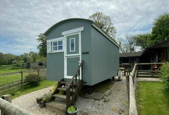 a shepherds hut set in the grounds of devon yurts
