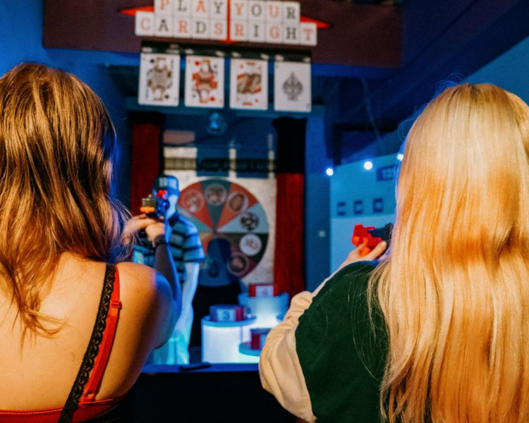 two girls shooting a target on an interactive game experience