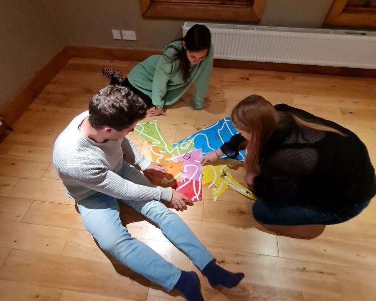 a family playing with a puzmat on the floor at home