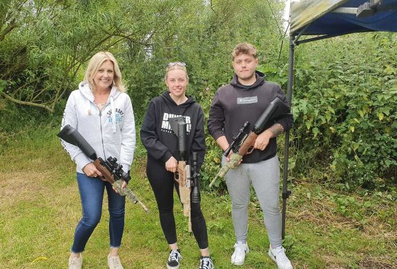 three people holding air rifles posing for photo on an air rifle shooting experience day