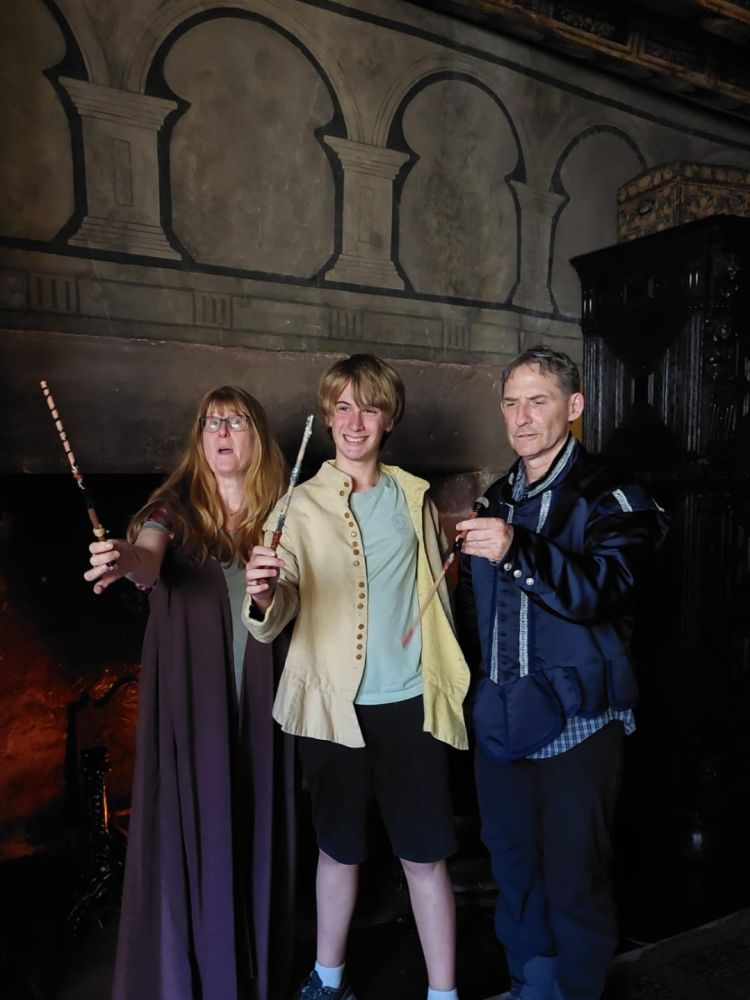 three people posing with the wands they have created at the school of magic in edinburgh