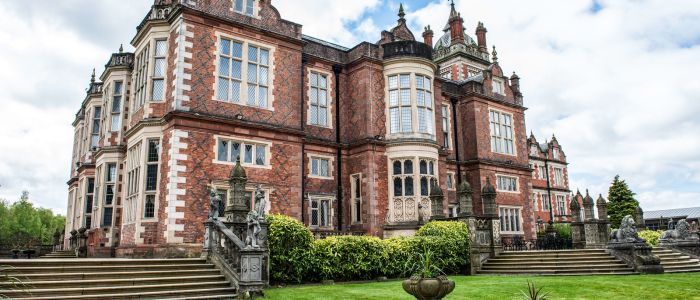exterior of q hotels crewe hall with manicured gardens surrounding it