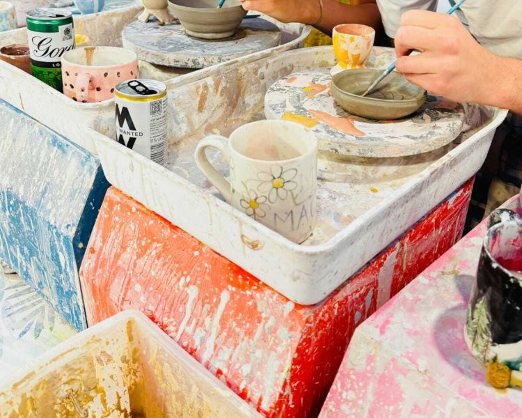 two people painting pottery on a pottery painting experience in london