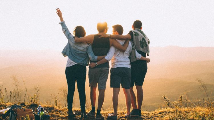 Group of friends looking out across view of hills in the sunshine
