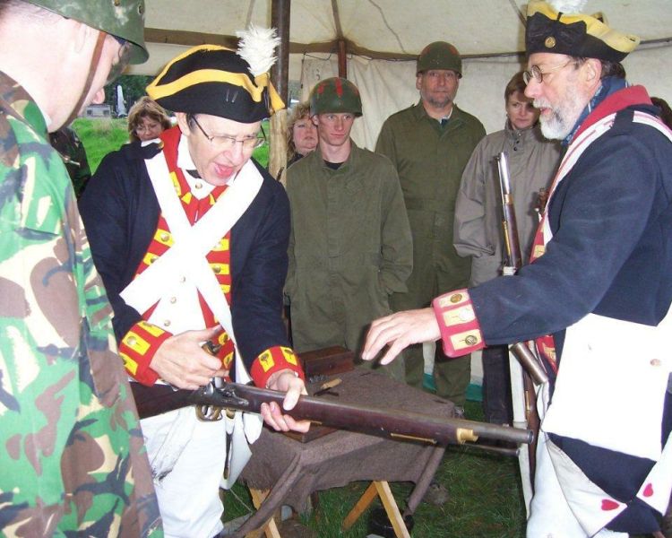 people being shown how to fire flinklocks and mortars a man firing 17th century flintlocks and mortars on a tank driving experience day
