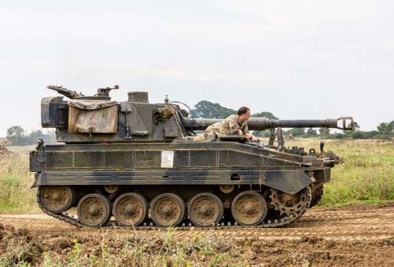 the abbott spg tank being driven across a muddy field on a tank driving experience day