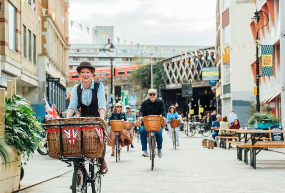 group of people riding vintage bicycles through london's streets on a bike sightseeing tour