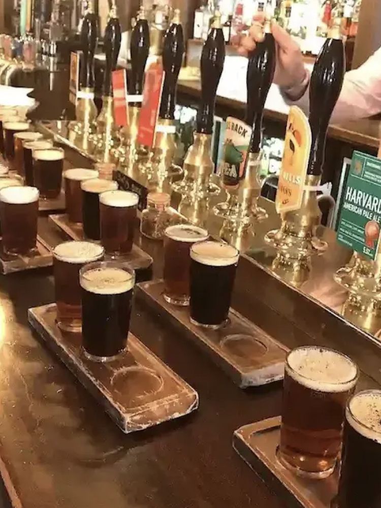 pints of beer lined up on a bar seen on a secret london pub walking tour