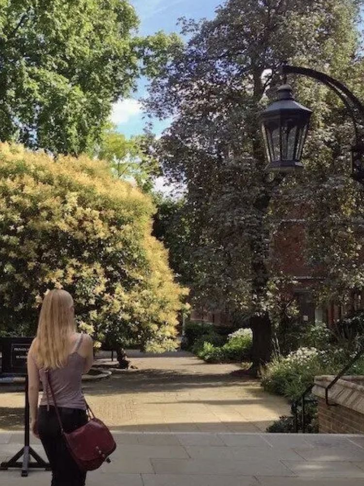 woman walking through a park in london seen on a secret london pub walking tour