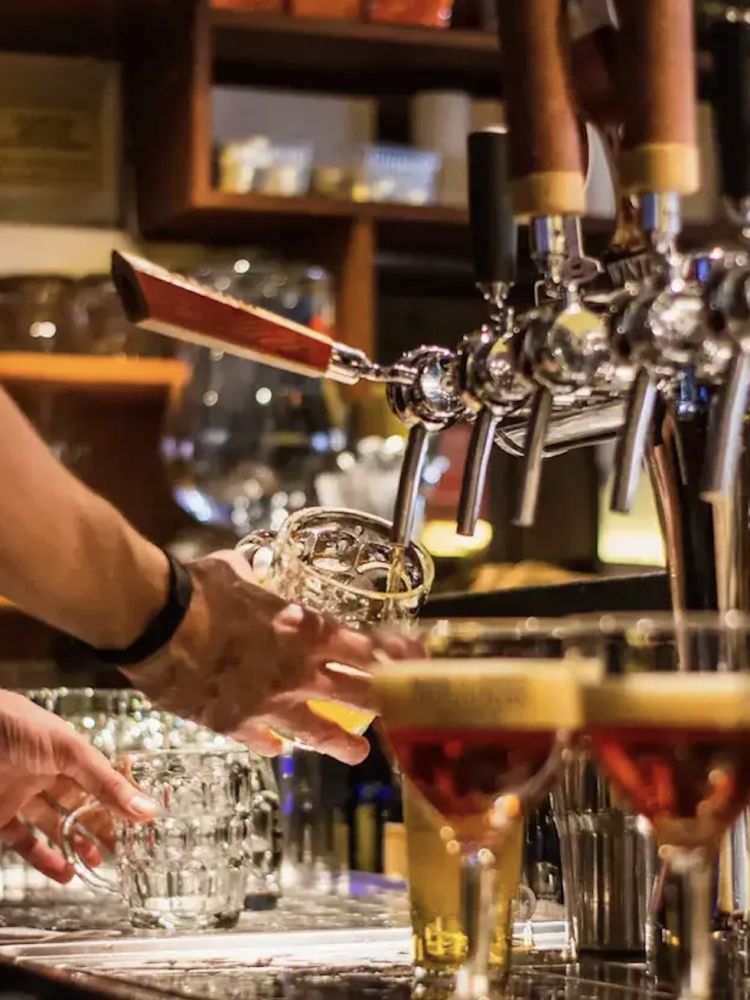 a pint of beer being poured into a glass in a bar seen on a secret london pub walking tour