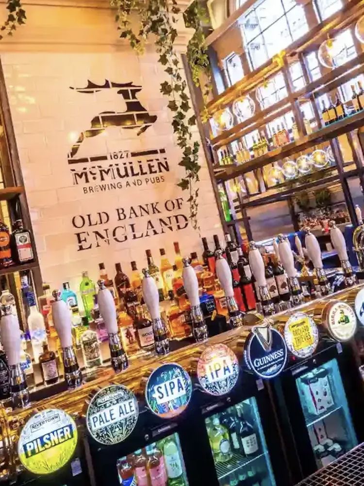 the bar inside an old pub in london showing all the beers and ales for sale seen on a secret london pub walking tour