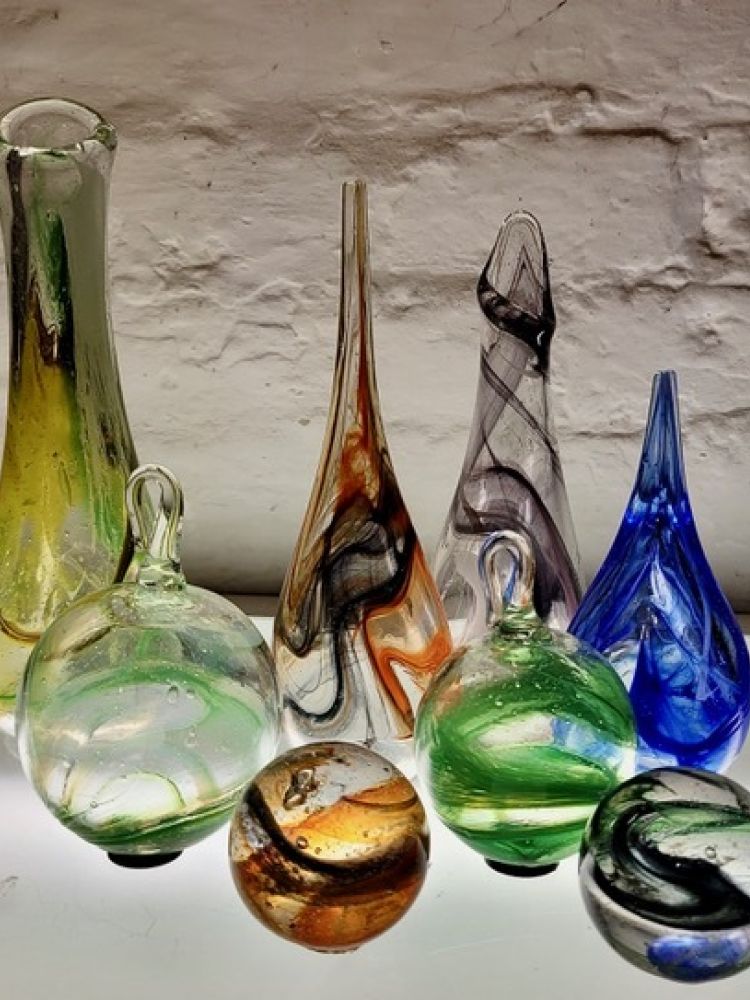 a collection of decorative coloured glass objects made on a glassblowing experience