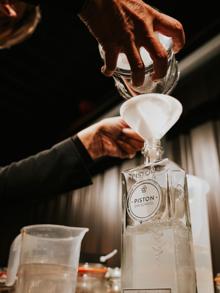 pouring into bottle on gin making experience in cheltenham