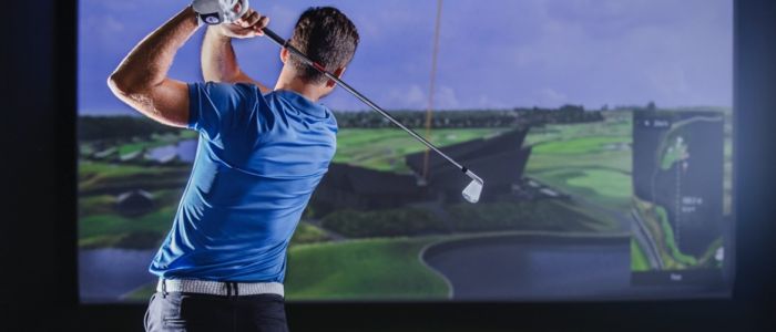 A man post-swing on the virtual golf experience