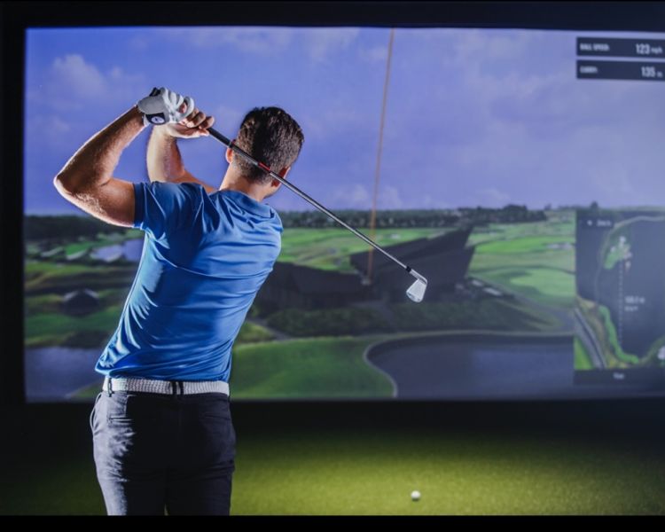 A man post-swing on the virtual golf experience