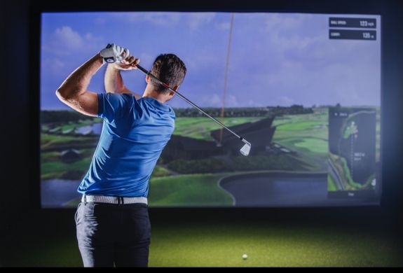 A man post-swing on the virtual golf experience