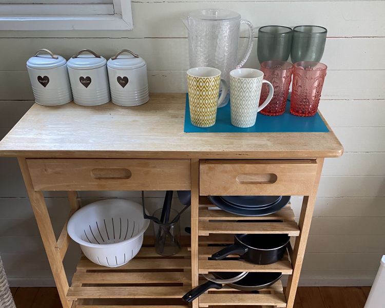 the crockery and utensils unit in the kitchen of a shepherds hut on a glamping site in dorset