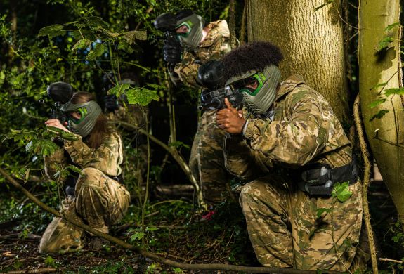young people dressed in camouflage gear on a paint ball experience