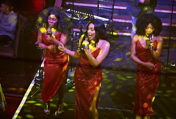 three singers on stage at a motown dining experience in london