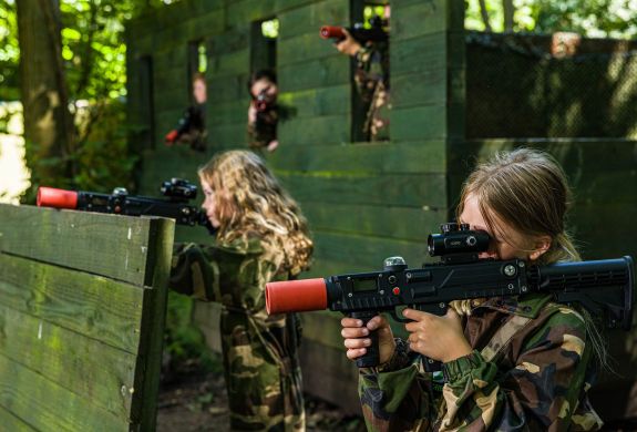 girls dressed in camouflage gear on a forest laser tag experience