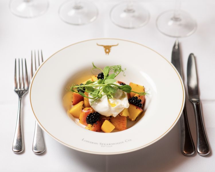 a fruit salad in a white bowl at marco pierre white's london steakhouse company