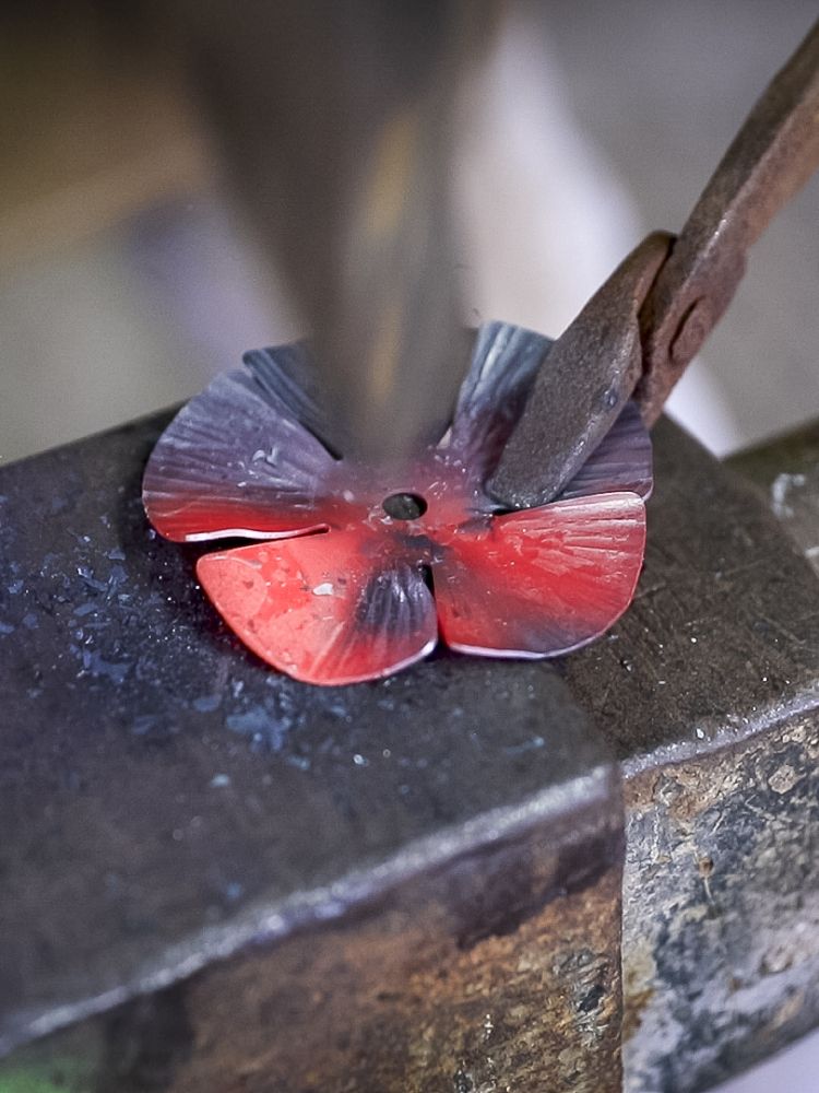 the petals of a rose being shaped with a hammer on a blacksmith experience