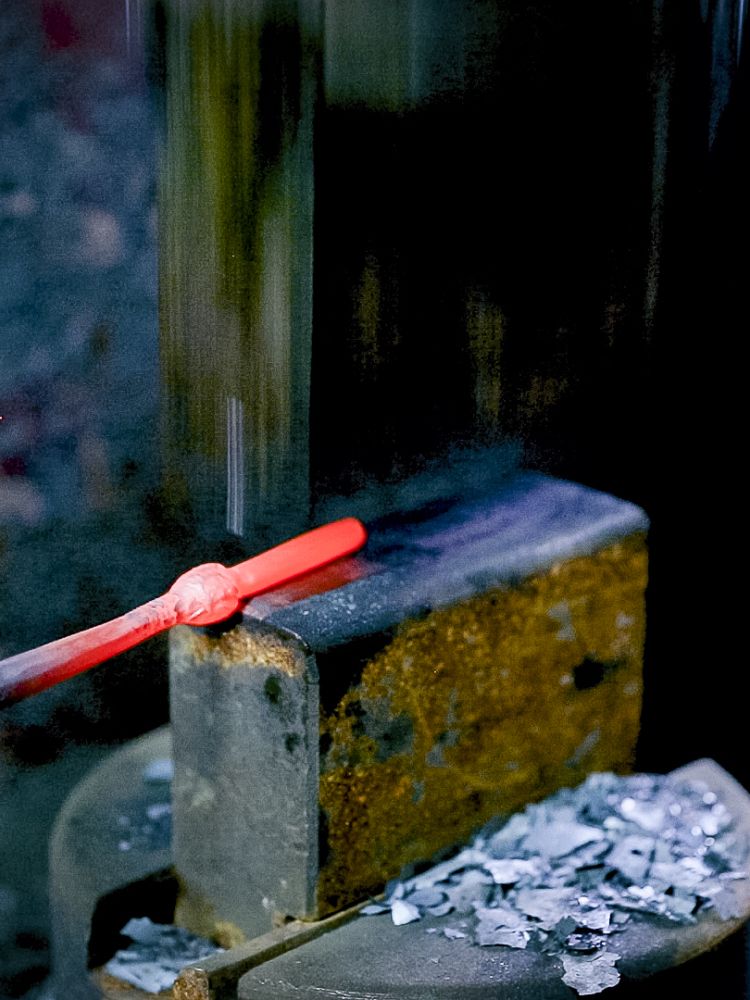 part of a tealight holder being formed into shape on a hydraulic hammer on a blacksmith experience