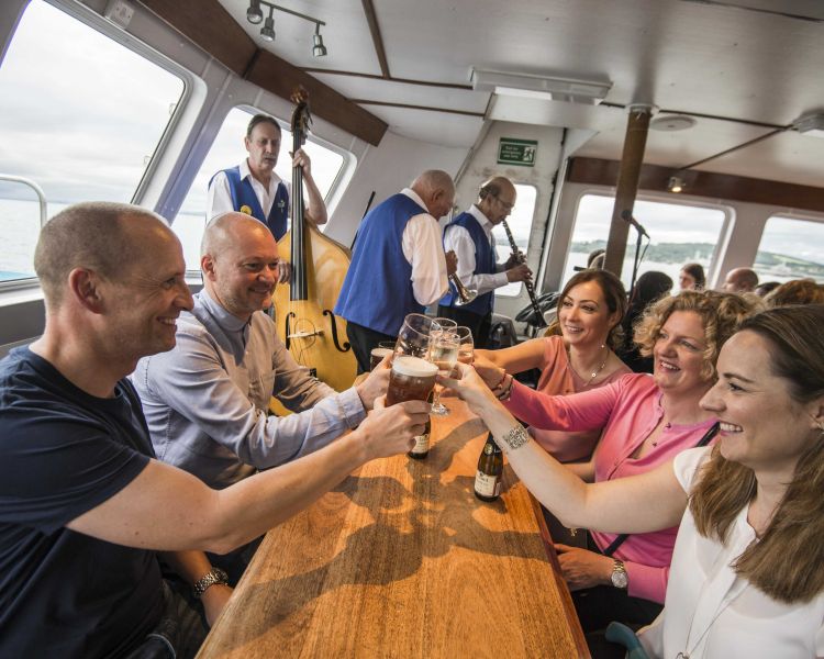 people enjoying a drink on an evening themed sightseeing cruise in scotland