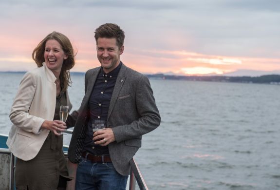 couple on the deck on a cruise boat on an evening themed sightseeing cruise in scotland
