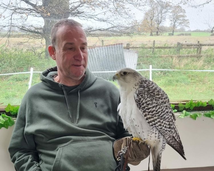 Man holding a white bird of prey