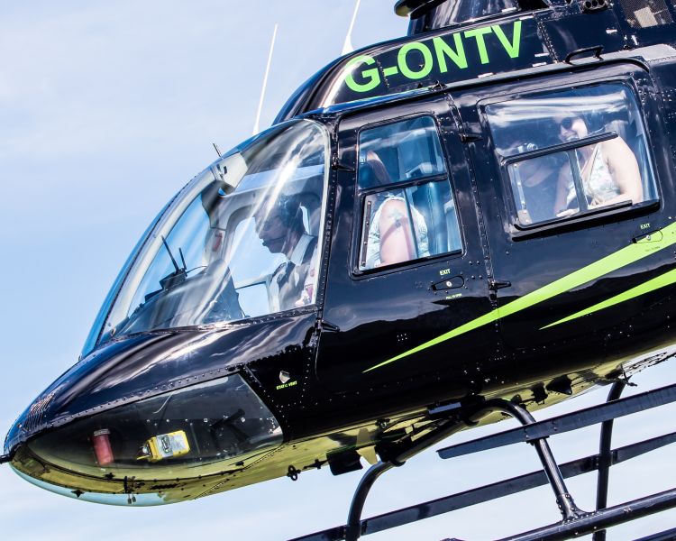 a black helicopter flying as part of a helicopter tour experience