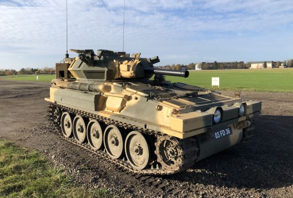 man driving a tank on a scorpion firing tank driving experience day