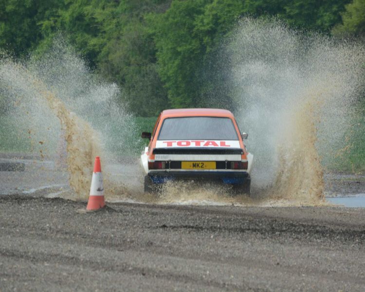a rally car being driven on a gravel track on a rally driving experience day