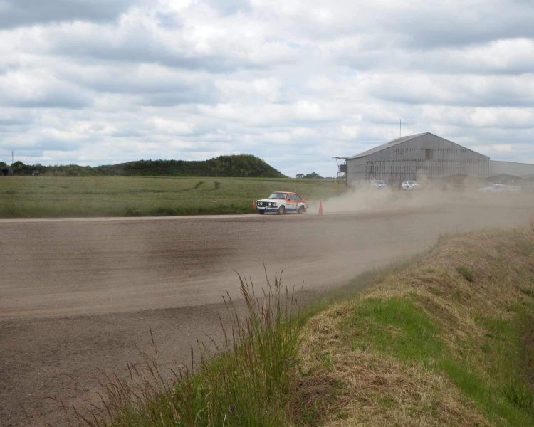 a rally car being driven along a gravel track on a rally driving experience day