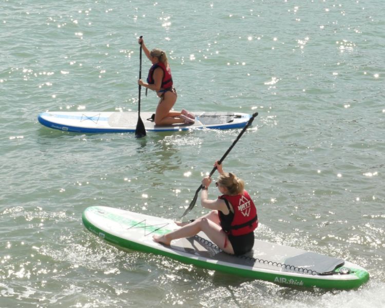2 women paddle boarding in the sun at SUP Hatt Adventures