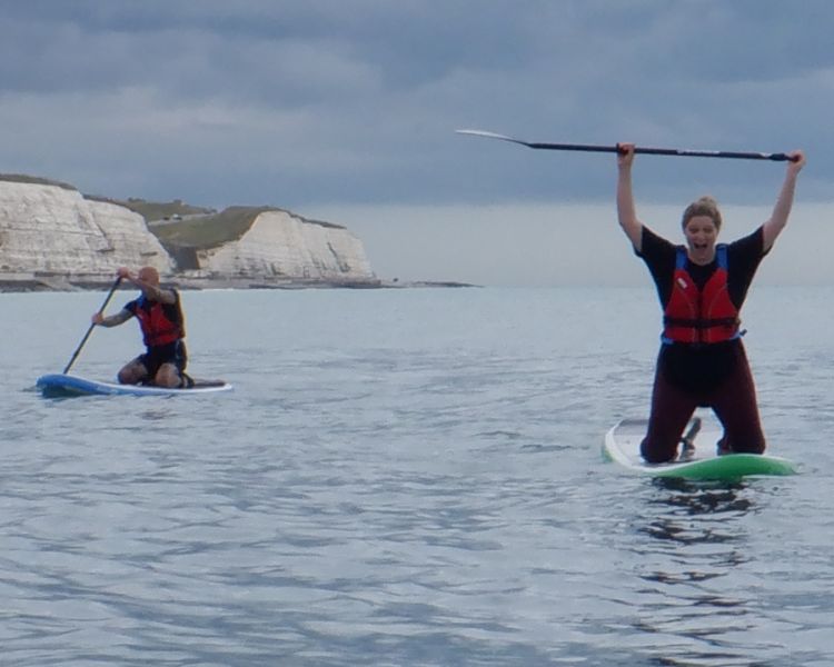 A man and woman paddle boarding at SUP Hatt Adventures