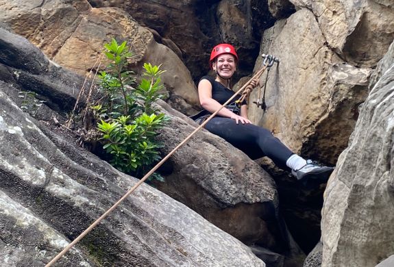 A low view of a woman sat on rocks at Climbing Exp Hatt Adventures