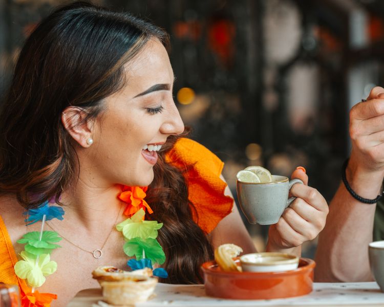 a man and a woman enjoying an afternoon tea with cuban inspired treats