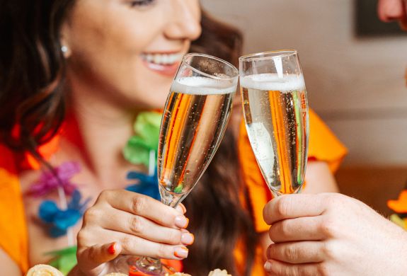 a woman and man with glasses of prosecco at a cuban inspired afternoon tea