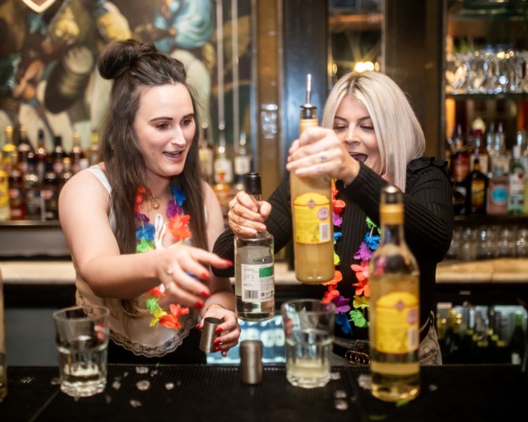 two ladies mixing cocktails on a cocktail masterclass at revolucion de cuba