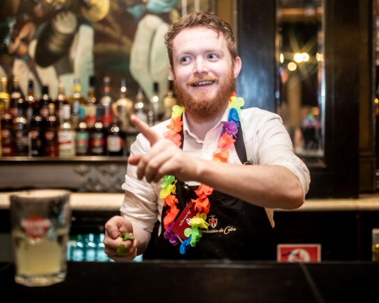 a bartender explaining how to make a cocktail on a cocktail masterclass at revolucion de cuba
