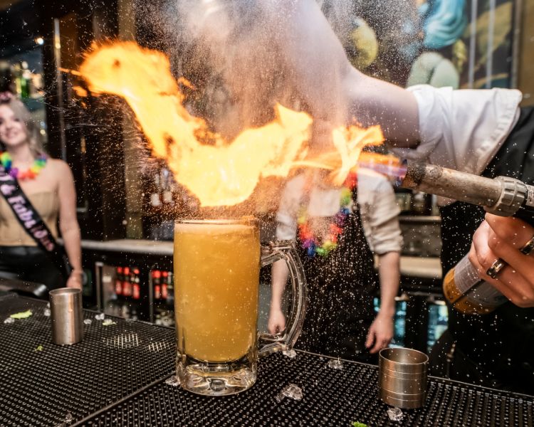 a bartender using a blowtorch on a cocktail on a cocktail masterclass at revolucion de cuba